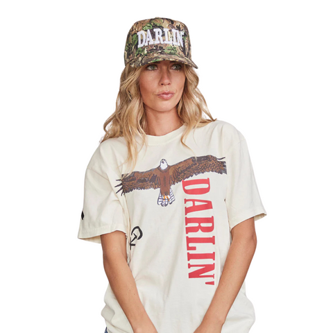 Person wearing the DARLIN' Cap in Heritage Camo White in a casual, outdoor or country-inspired setting