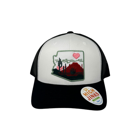 Front view of the High Jinks Heart of the Desert Trucker hat in black and white, featuring a bold graphic patch centered on the front panel.
