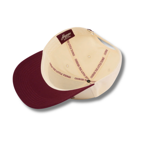 Flat lay of Huega House Athletic Association Hat in Maroon/Natural highlighting classic athletic logo embroidery and clean two-tone design