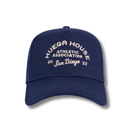 Front view of Huega House Athletic Association Hat in Navy featuring vintage-inspired “Huega House Athletic Association” embroidery on a structured crown with a curved brim