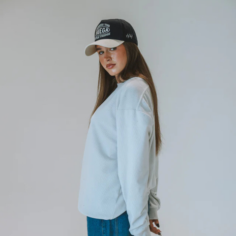 Person wearing the Huega House Circuit Hat in Natural and Navy in a relaxed urban or outdoor setting