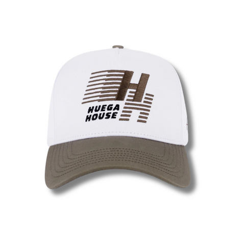 Front view of Huega House Legacy Hat in Cement and White featuring embroidered “Huega House Legacy” text on a structured cement-colored crown with a crisp white curved brim