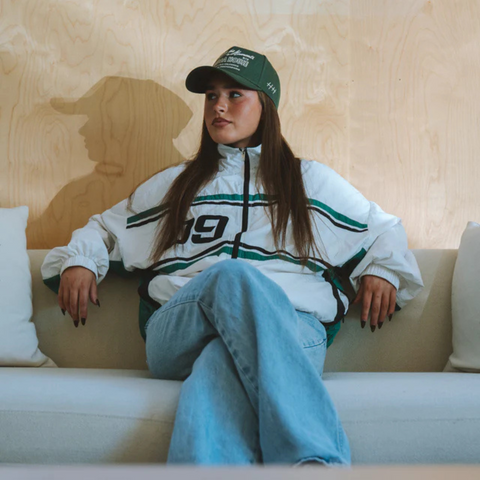 Person wearing the Huega House Moments Hat in Pine Green in a relaxed outdoor or casual everyday setting