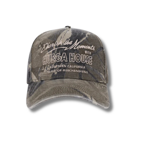 Front view of Huega House Moments Hat in Vintage Camo featuring bold “Moments” embroidery on a structured crown with a classic camo pattern and curved brim
