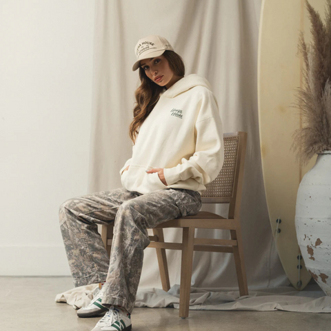 Person wearing the Huega House Trademark Hat in Khaki in a casual, outdoor or lifestyle setting