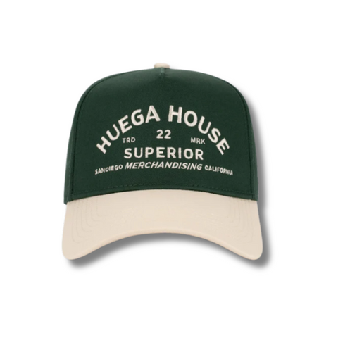 Front view of Huega House Trademark Hat in Natural and Green featuring embroidered Huega House logo on a structured crown with a forest green curved brim