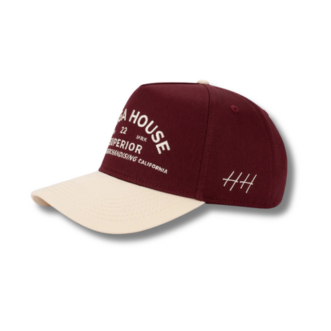 Side view of Huega House Trademark Hat in Natural/Maroon showing curved maroon brim, mid-profile fit, and smooth natural-tone crown