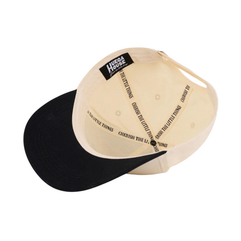 Flat lay of Huega House Vintage Swan Hat in Black/Natural highlighting the embroidered swan patch, contrast brim, and structured crown