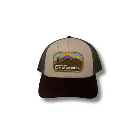 Front view of Local Stated Painted Desert Hat in Tan, Brown, and Green featuring a desert landscape patch on a structured crown with a curved brim