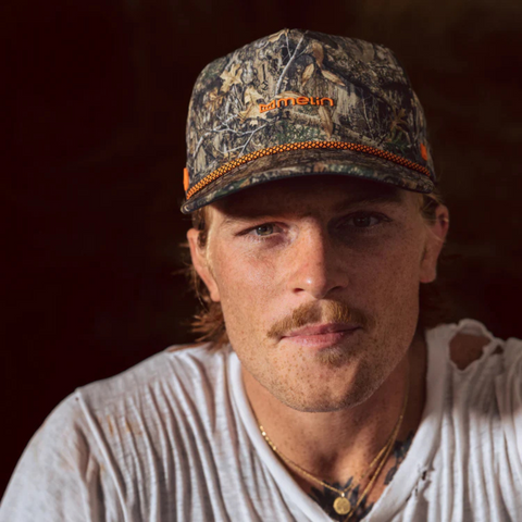 Person wearing the Melin Coronado Real Tree Hydro Hat in Edge in an outdoor, adventure-ready environment