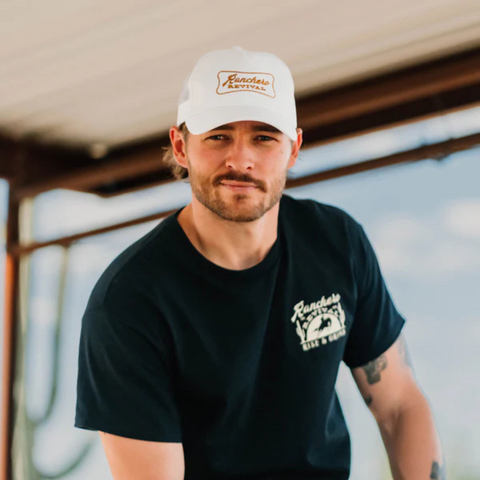 Person wearing the white Ranchero Revival Ranchero Trucker Hat in a casual, outdoor setting