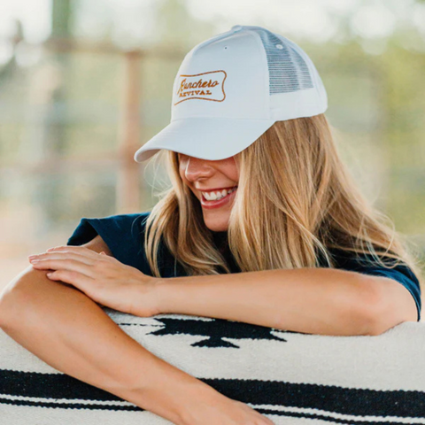 Person wearing the white Ranchero Revival Ranchero Trucker Hat in a casual, outdoor setting