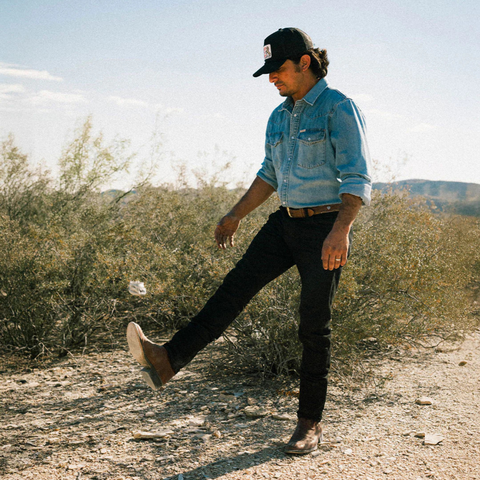 Person wearing the Sendero Cowboy Pro Shop Hat in Black in a laid-back outdoor or golf-themed setting