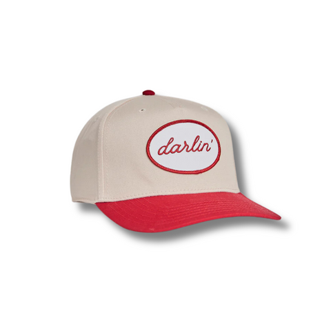 Front view of DARLIN'® Snapback in Cream and Red featuring a structured crown with a white embroidered patch and bold red “DARLIN'” text