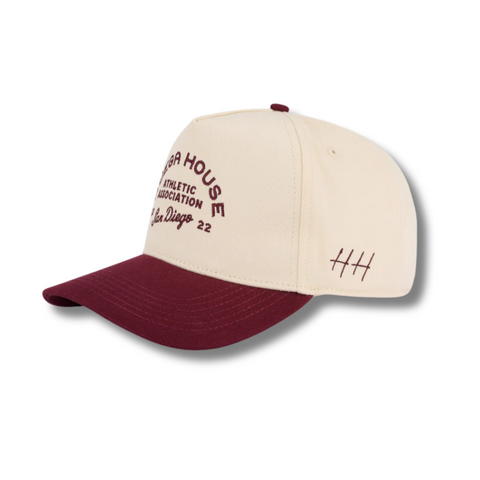 Side view of Huega House Athletic Association Hat in Maroon/Natural showing contrast brim, mid-profile fit, and breathable cotton construction