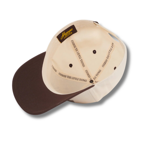 Flat lay of Huega House Legacy Hat in Brown/Natural highlighting the clean embroidered logo, curved brim, and classic two-tone colorway