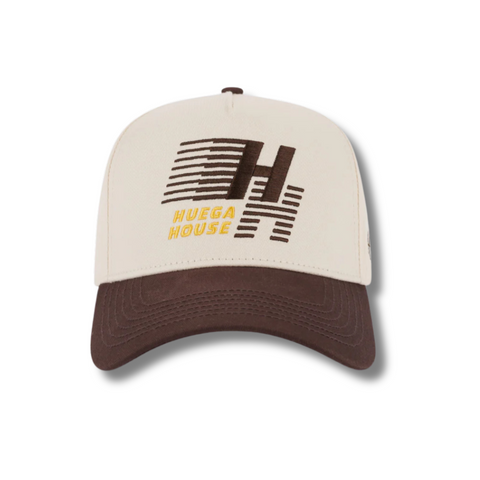 Front view of Huega House Legacy Hat in Brown and Natural featuring embroidered “Huega House Legacy” text on a structured brown crown with a contrasting natural curved brim