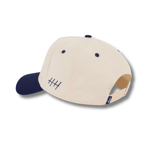 Back view of Huega House Legacy Hat in Navy and Natural with adjustable strap and metal buckle for a custom, secure fit