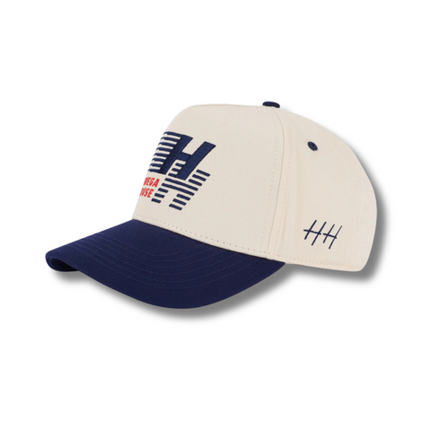Side view of Huega House Legacy Hat in Navy/Natural showing mid-profile fit, breathable paneling, and a contrasting two-tone color scheme