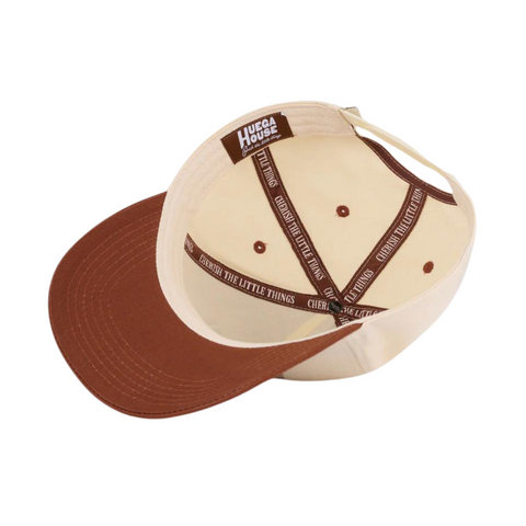 Flat lay of Huega House Legacy Hat in Rust highlighting minimalist front embroidery, curved brim, and warm earthy color