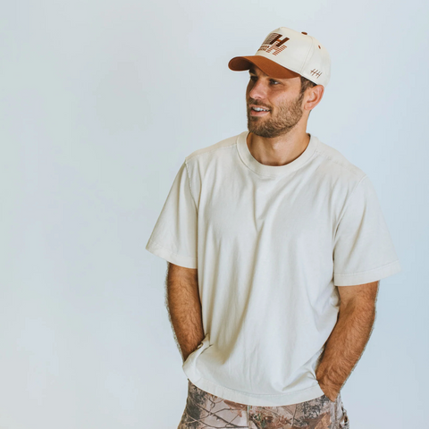 Person wearing the Huega House Legacy Hat in Rust in a casual or outdoor fall-inspired setting