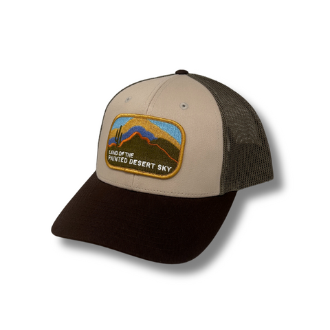 Front view of Local Stated Painted Desert Hat in Tan, Brown, and Green featuring a desert landscape patch on a structured crown with a curved brim