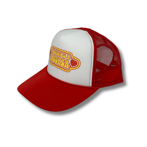 Side angle of the Rodeo Hippie "My Daddy’s a Trucker" hat, showing the curved brim and mesh back in a classic trucker style.
