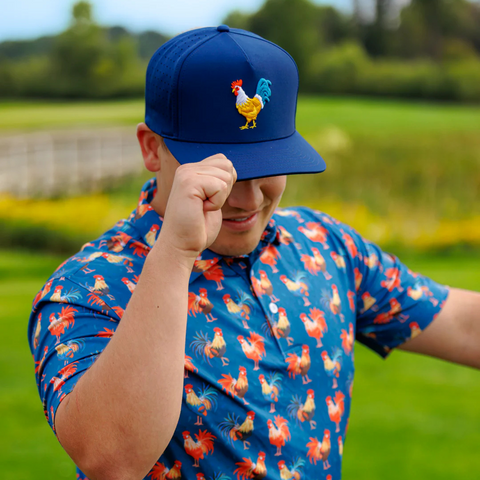 Person wearing the Waggle Feelin' Cocky Hat in Navy on the golf course or in a relaxed outdoor setting with playful style